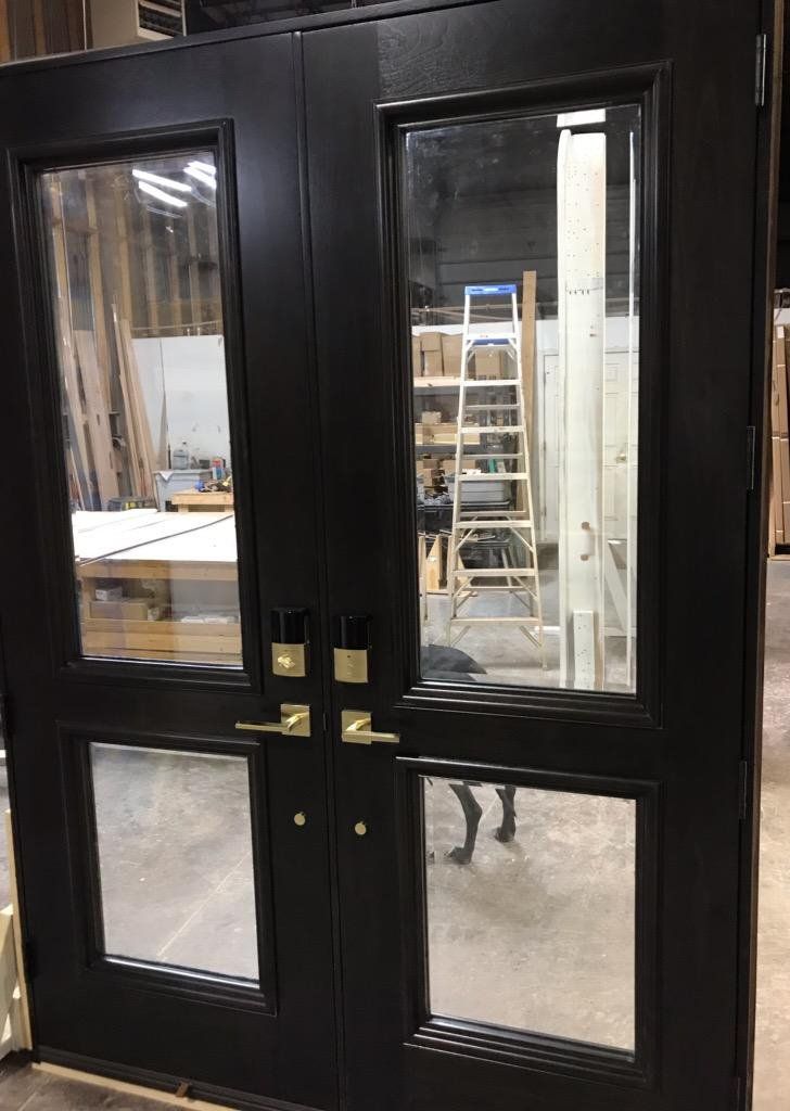 A pair of black doors with glass in a warehouse.