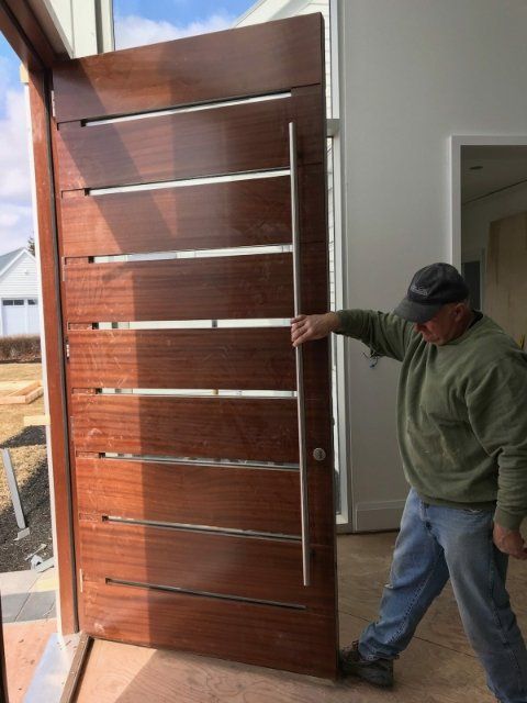 A man is pushing a large wooden door