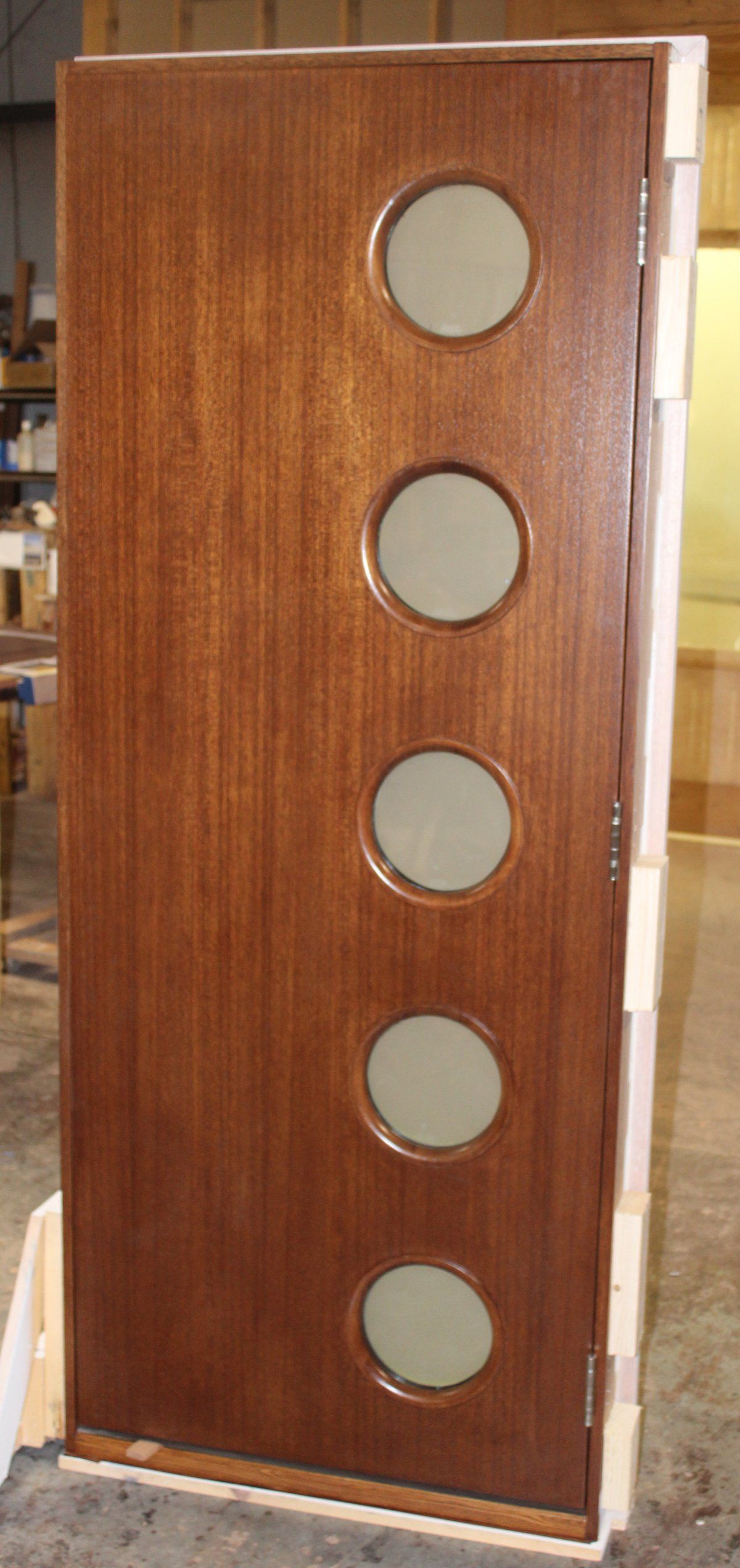 Mid-century modern mahogany exterior door with circle windows offset on side painted on one side and stained on the other