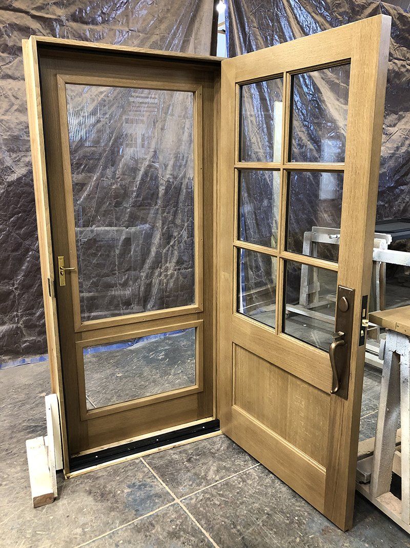 A wooden door is sitting on a tiled floor in a room.