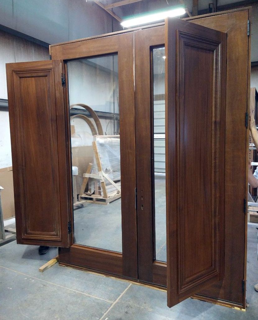 A large wooden door is being built in a factory