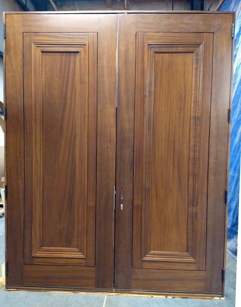 A pair of wooden doors with a blue tarp behind them