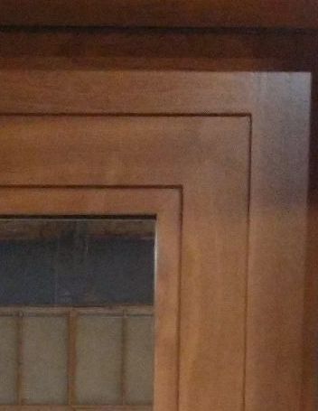 A close up of a wooden cabinet with a glass door.