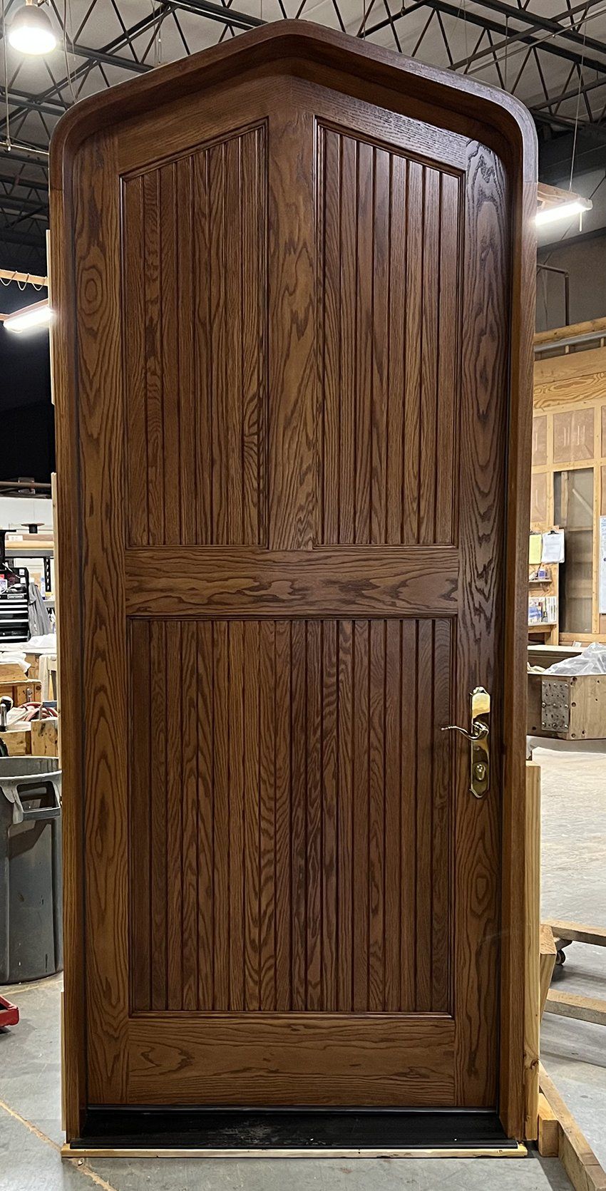 A wooden door is sitting on a concrete floor in a building.