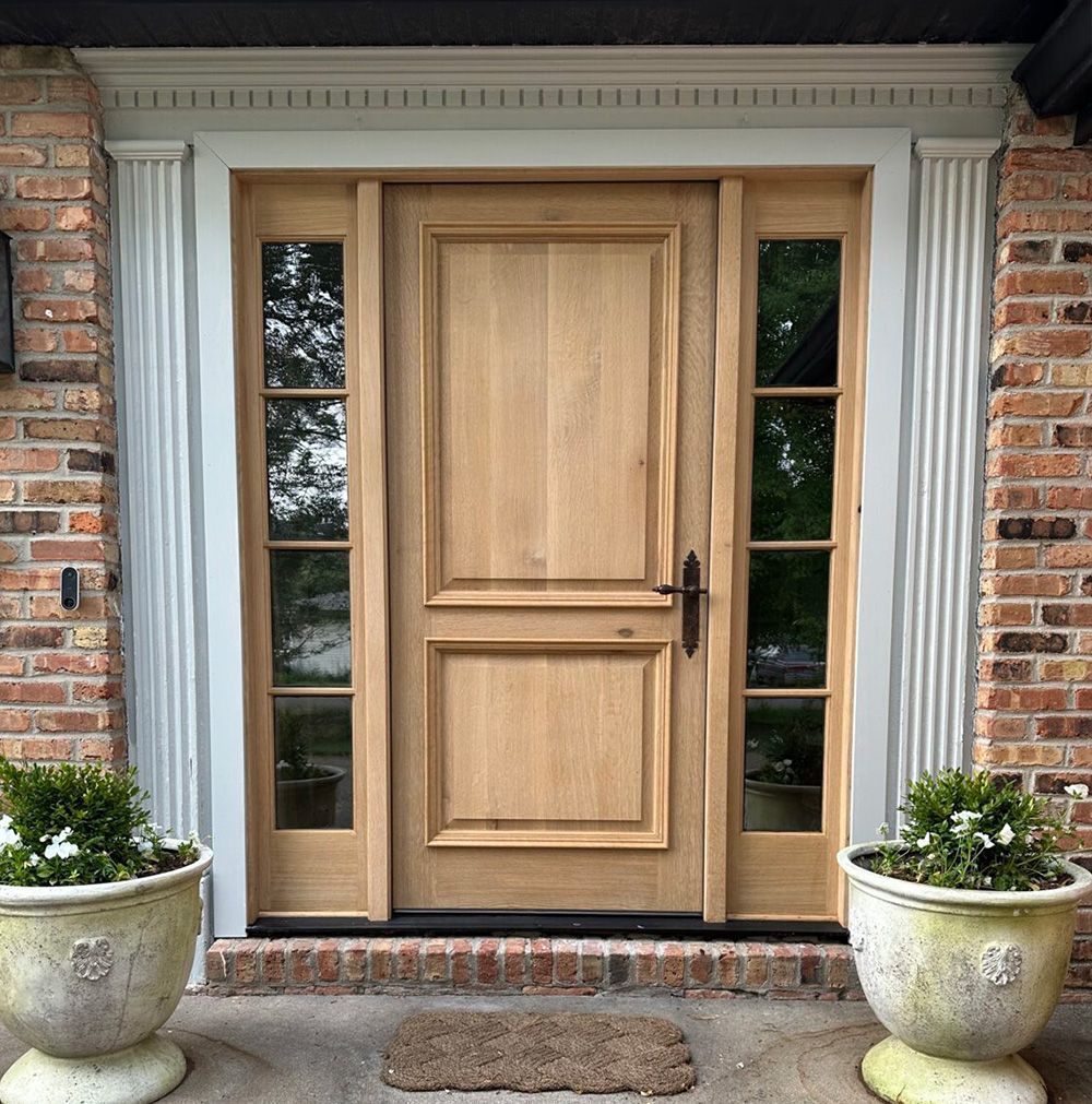 The front door of a brick house with a wooden door