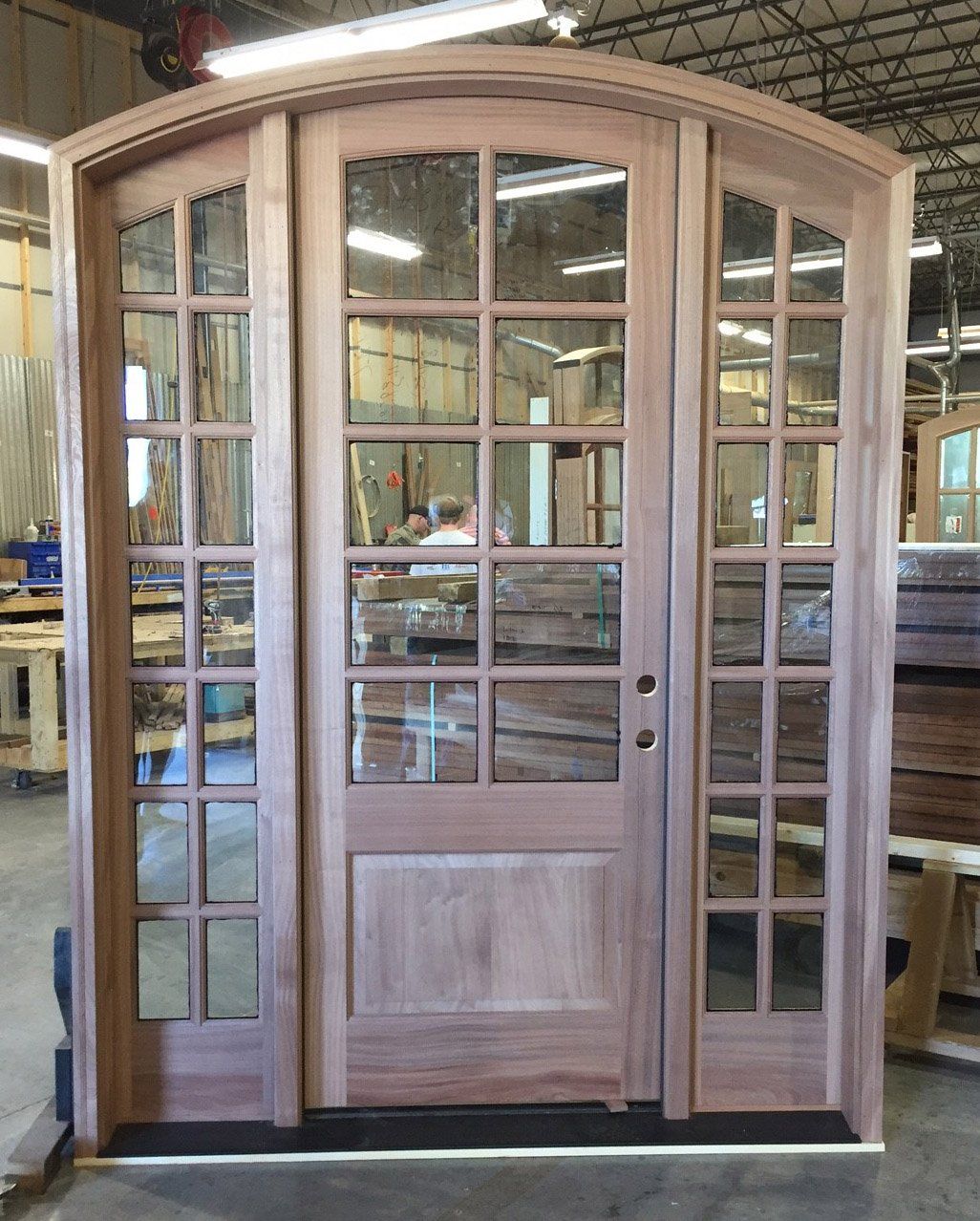 A large wooden door is being built in a factory