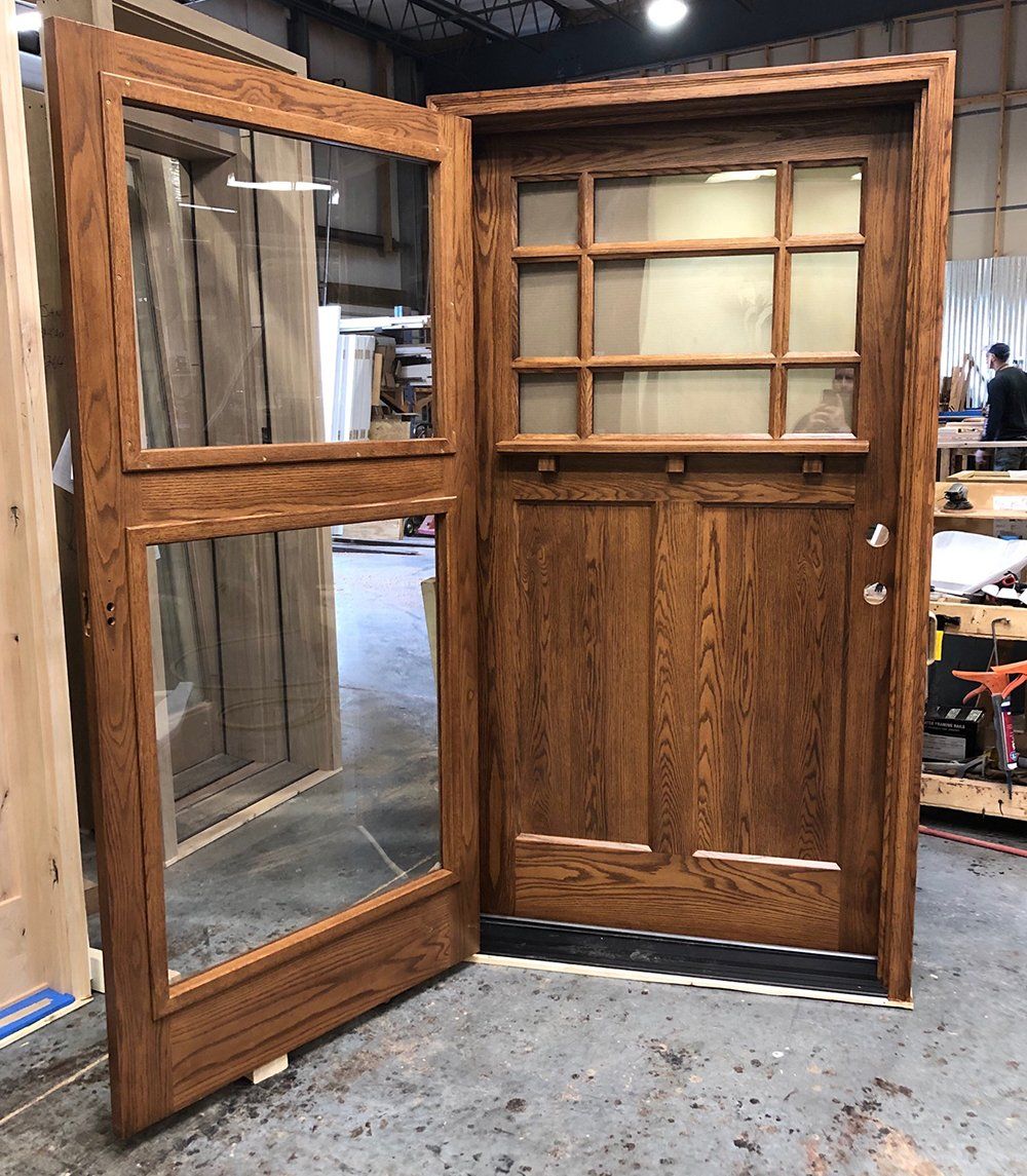 A wooden door with glass panels is open in a warehouse
