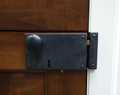 A close up of a door lock on a wooden door.