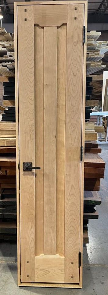 A wooden door is sitting on top of a pile of wood in a warehouse.