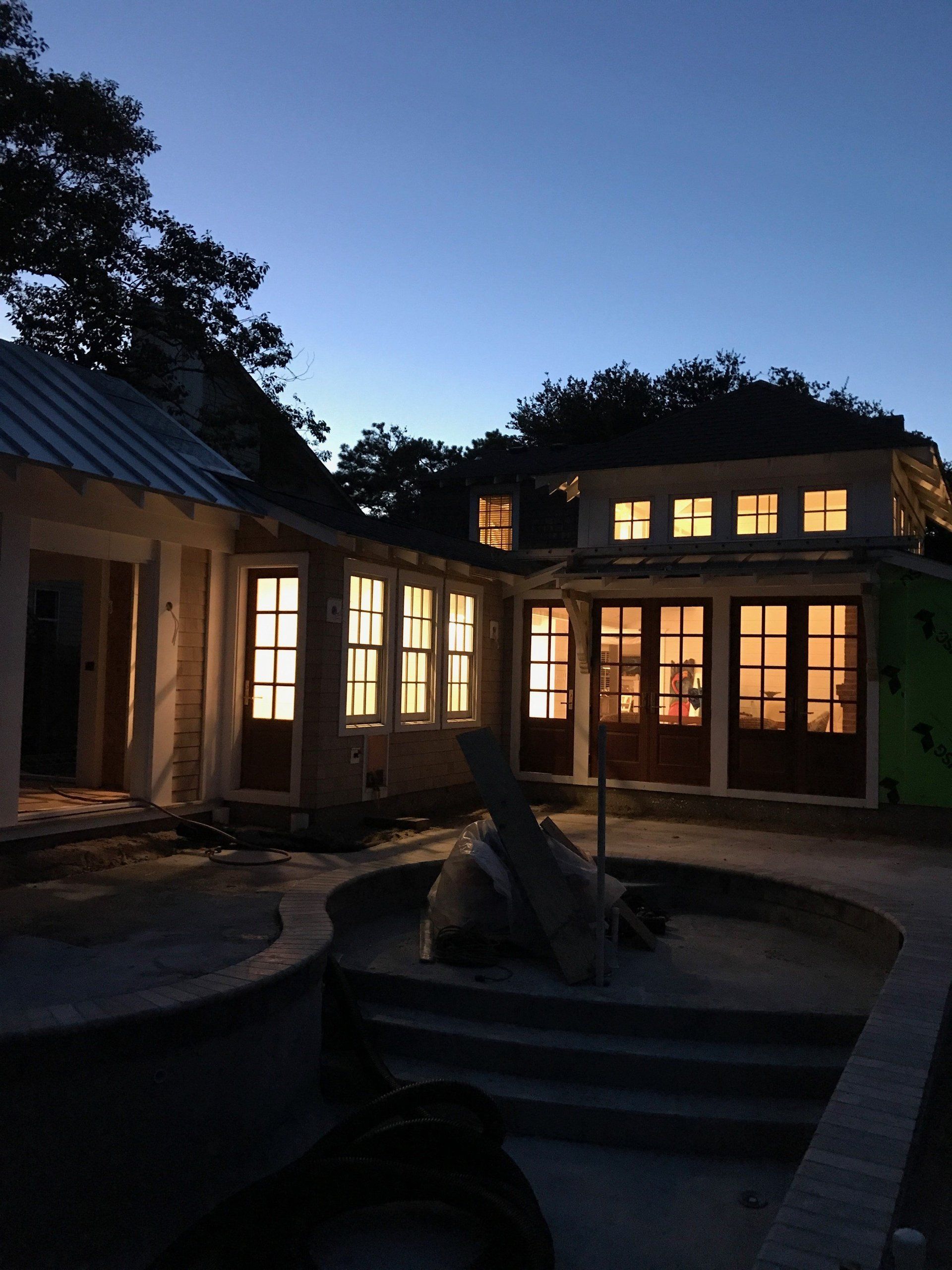 A house with a lot of windows is lit up at night