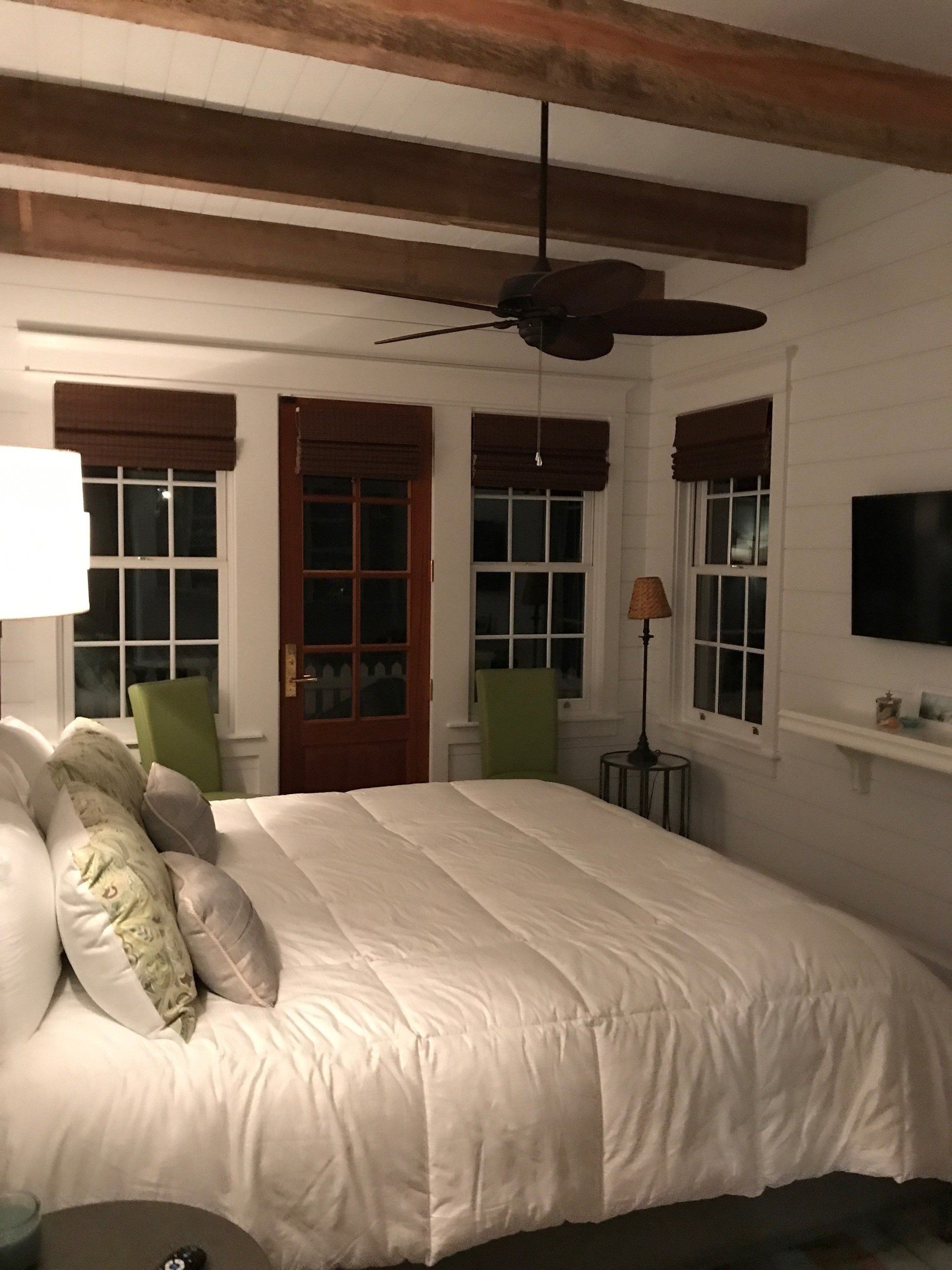 A bedroom with a large bed and a ceiling fan