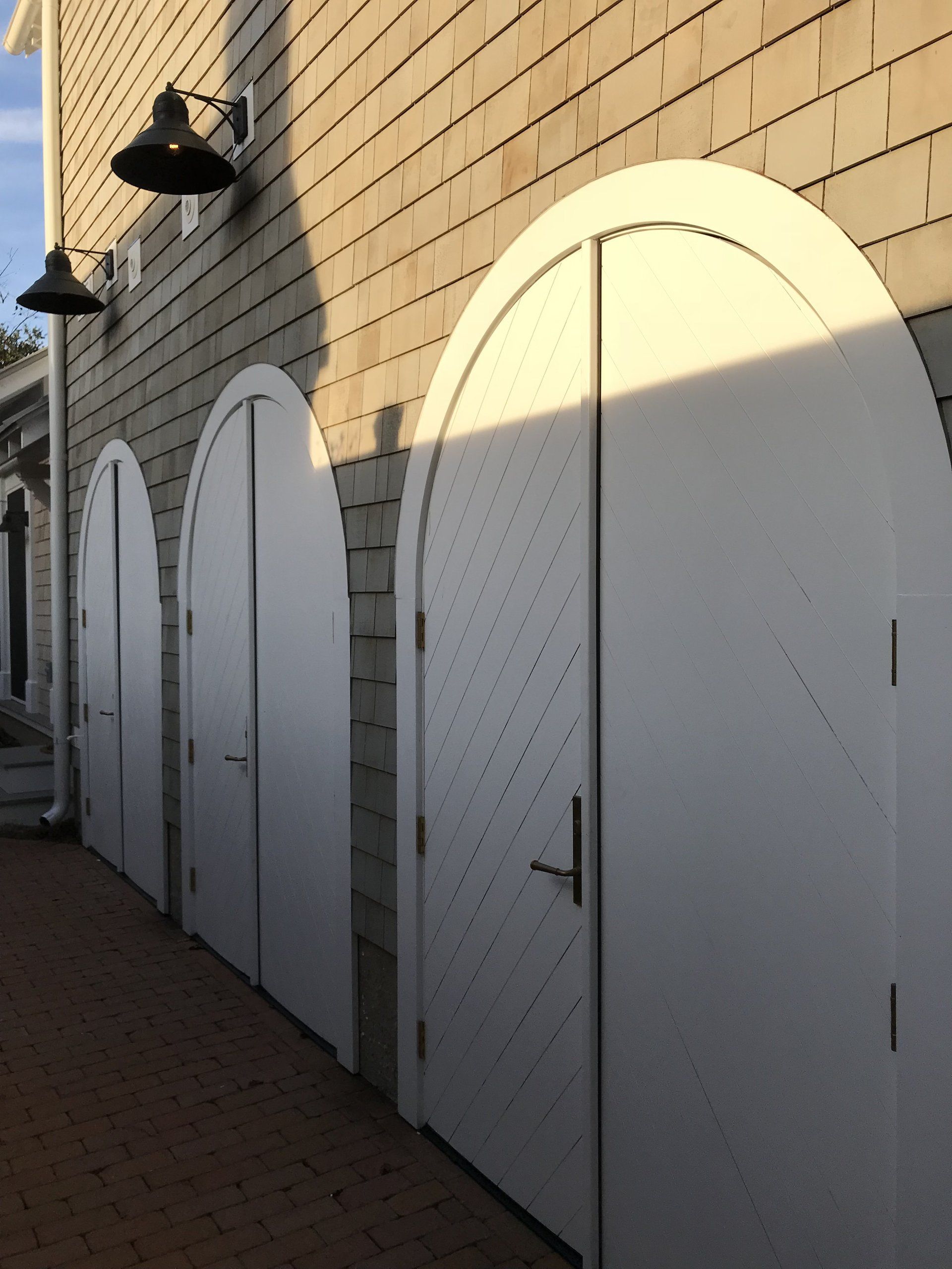 A row of arched white doors on the side of a building