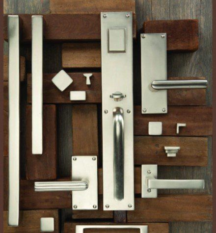 A bunch of stainless steel door handles on a wooden surface