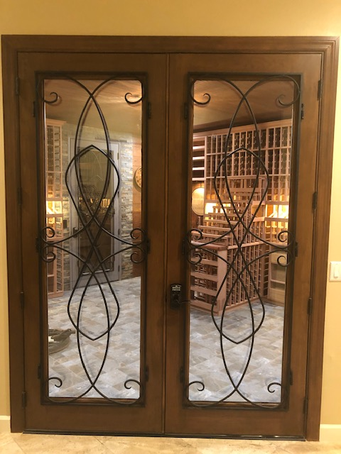 Custom mahogany interior door for wine cellar features iron grille