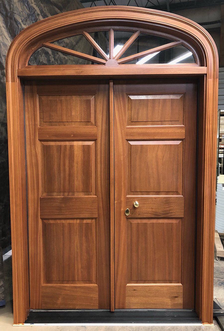 A wooden door with a window above it is sitting on a table.