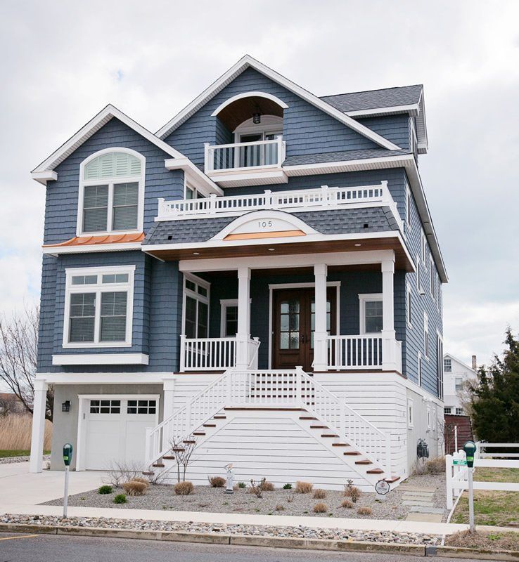 A large blue and white house with a large porch