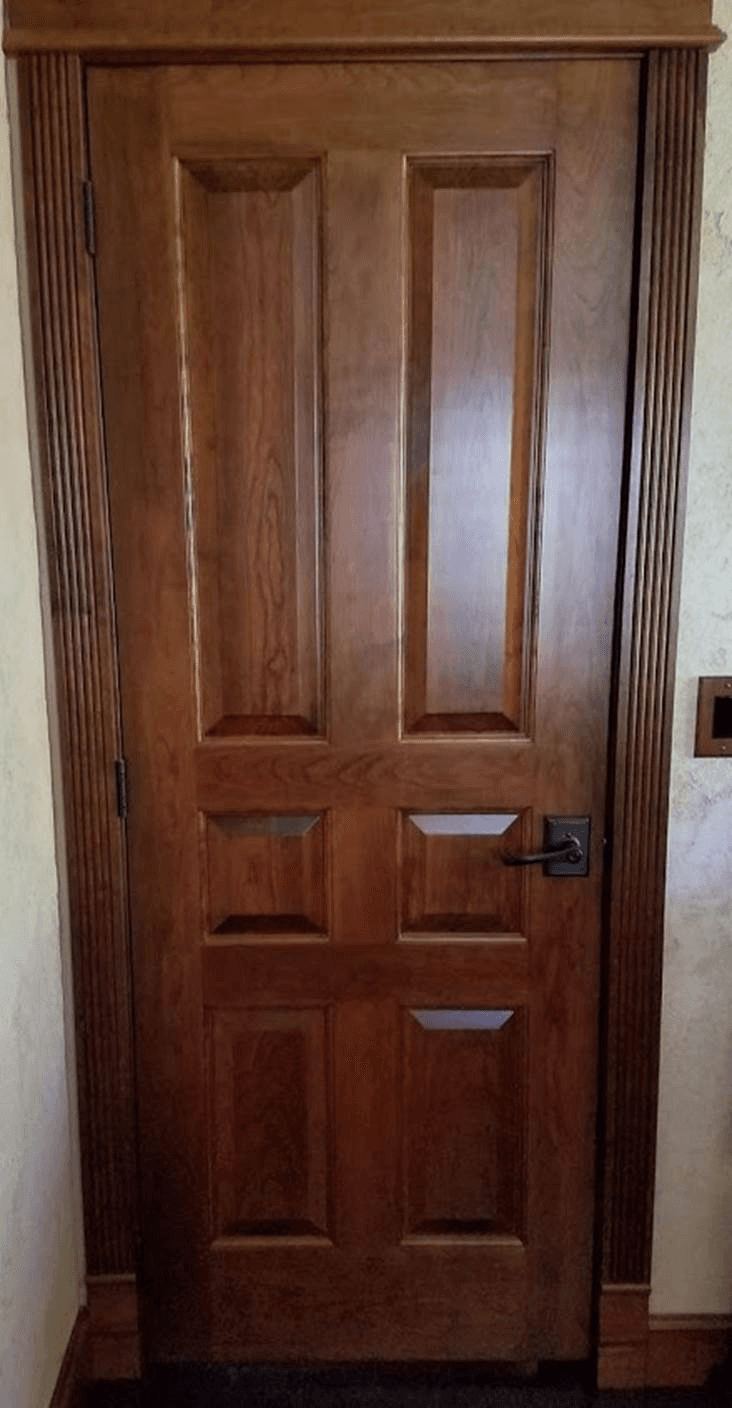 A close up of a wooden door in a room.