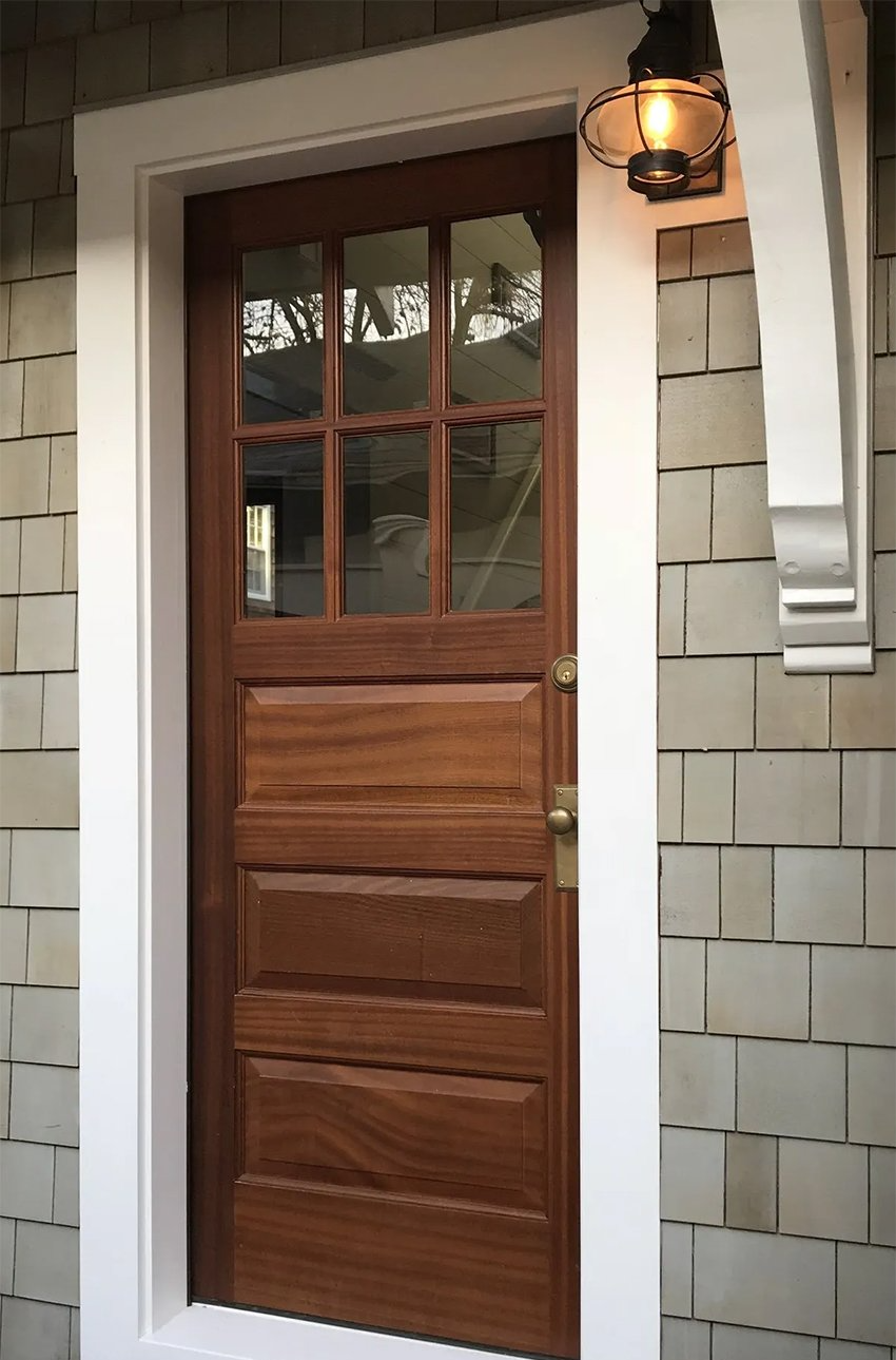A wooden door with a lantern on the side of it
