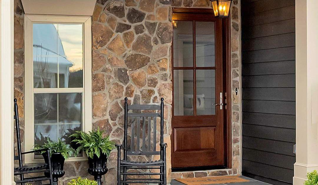 There is a rocking chair on the porch of a house.
