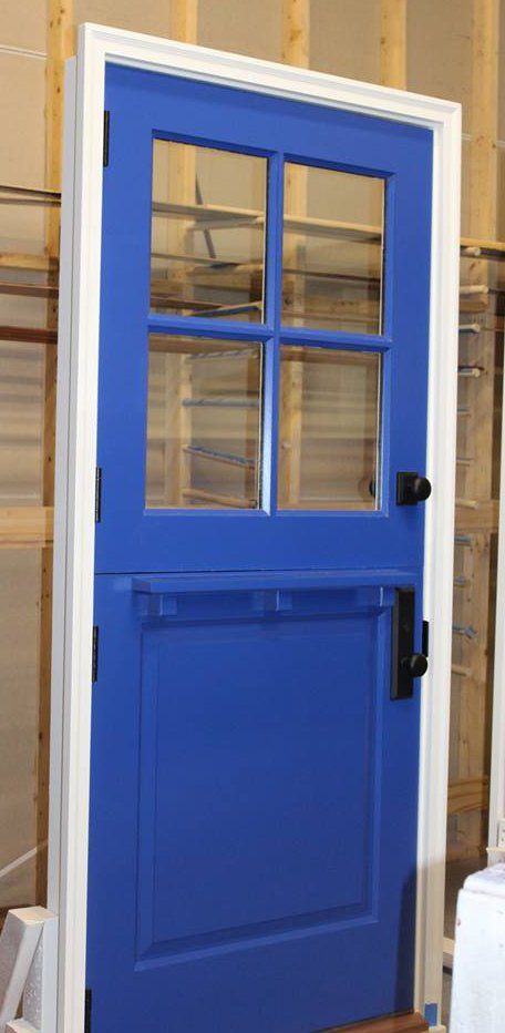 A blue door with four windows is sitting in a room.