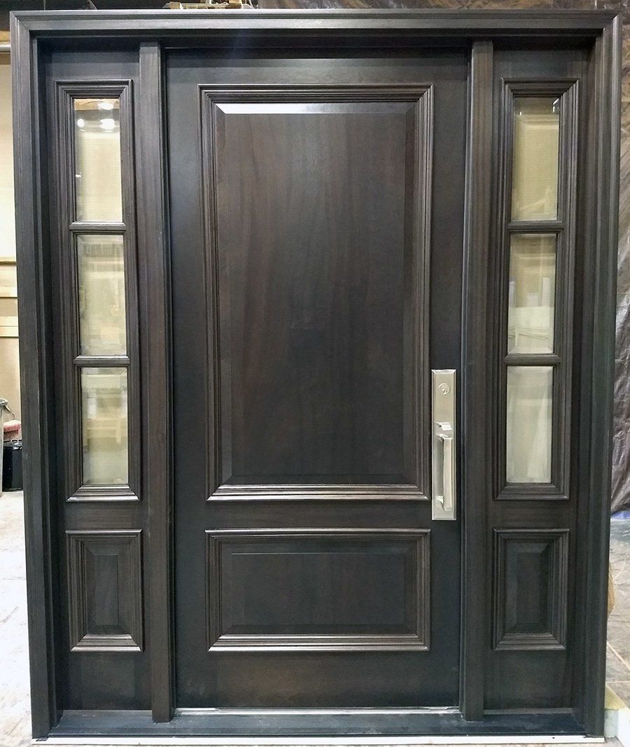 A large wooden door with three windows is sitting on a table.