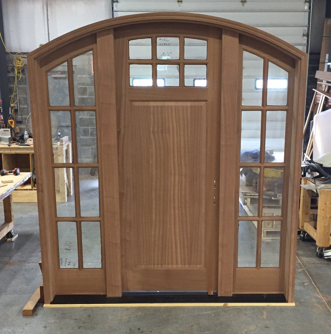 A large wooden door is sitting in a workshop