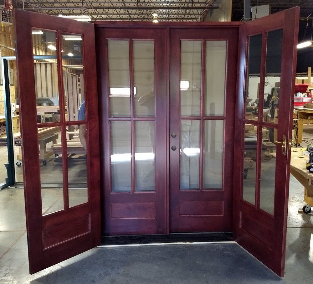 A wooden door with glass panels is open in a workshop