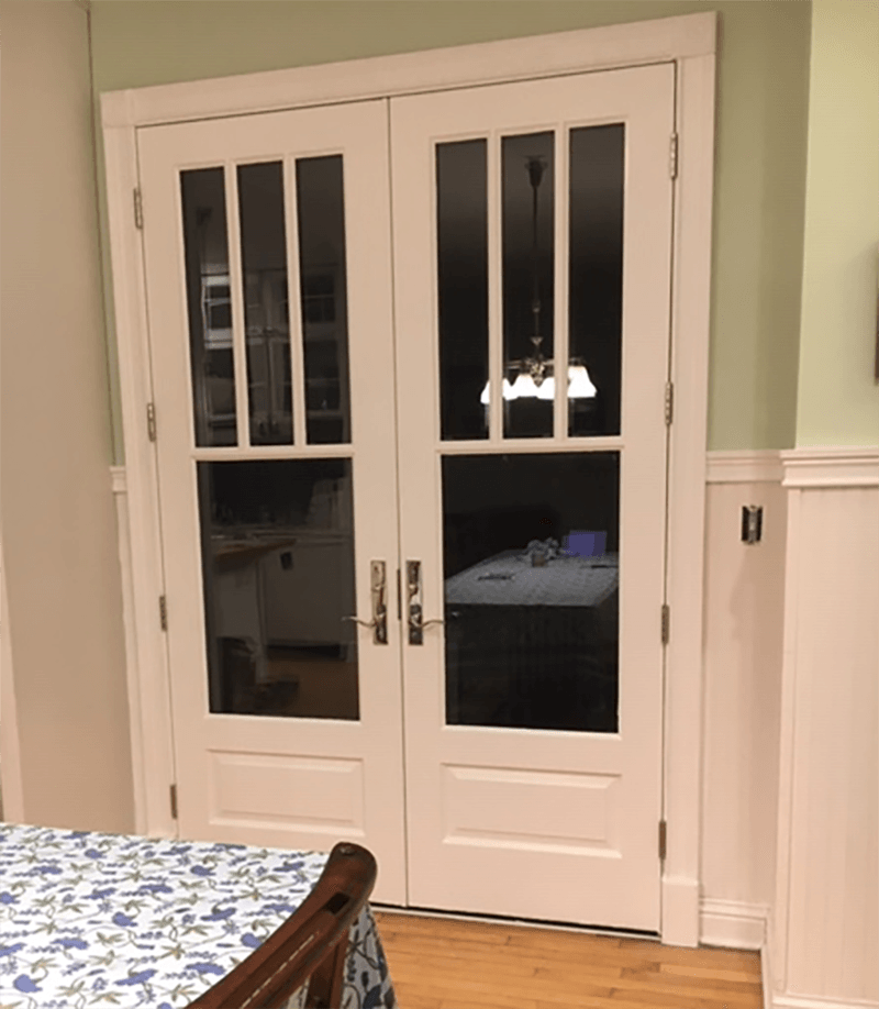 A dining room with a table and chairs and french doors
