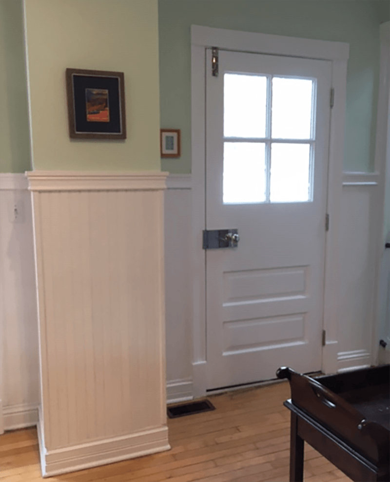 A white door with a picture on the wall above it