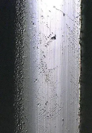 A close up of a metal surface with a lot of small holes in it.