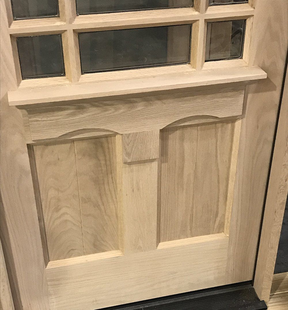 A close up of a wooden door with a glass window.