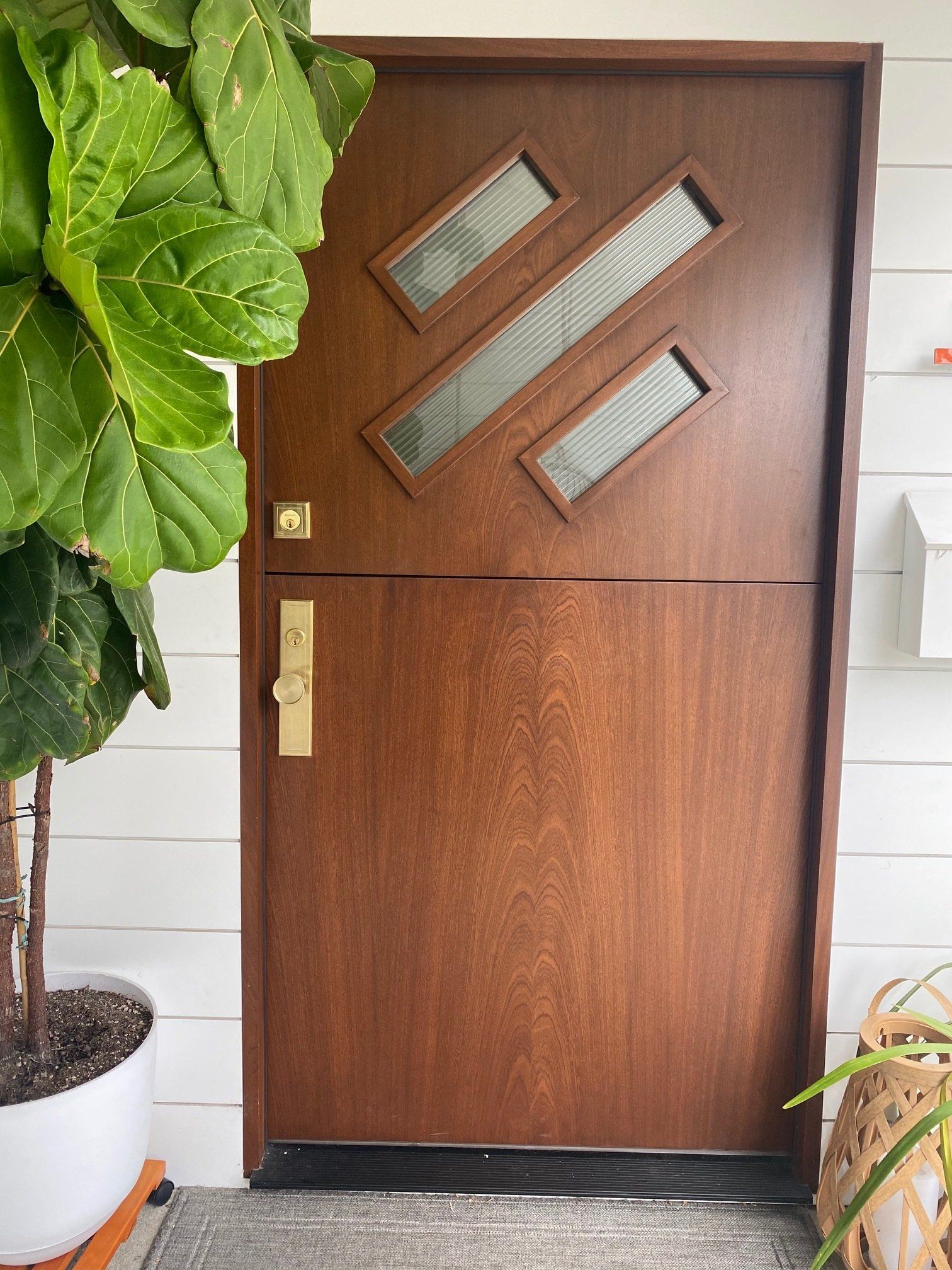 mahogany modern wood door with reeded glass in upper panel.
