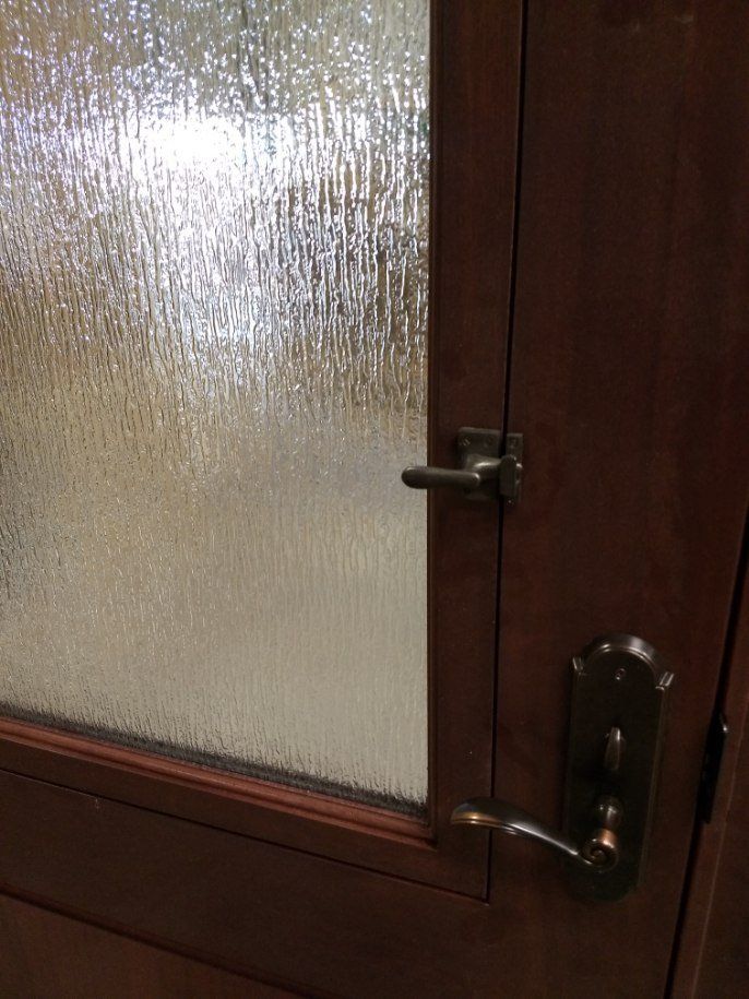 A close up of a door with a handle and glass