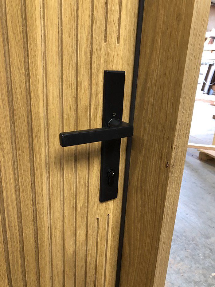 A wooden door with a black door handle on it