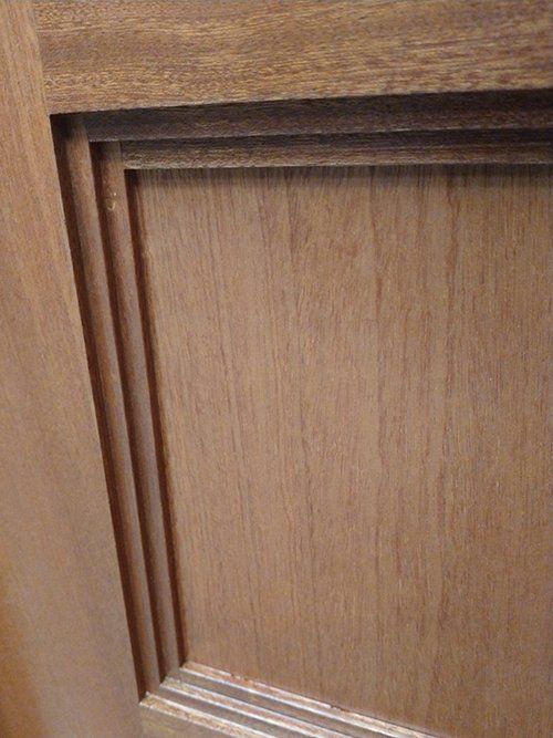 A close up of a wooden door with a wooden frame.