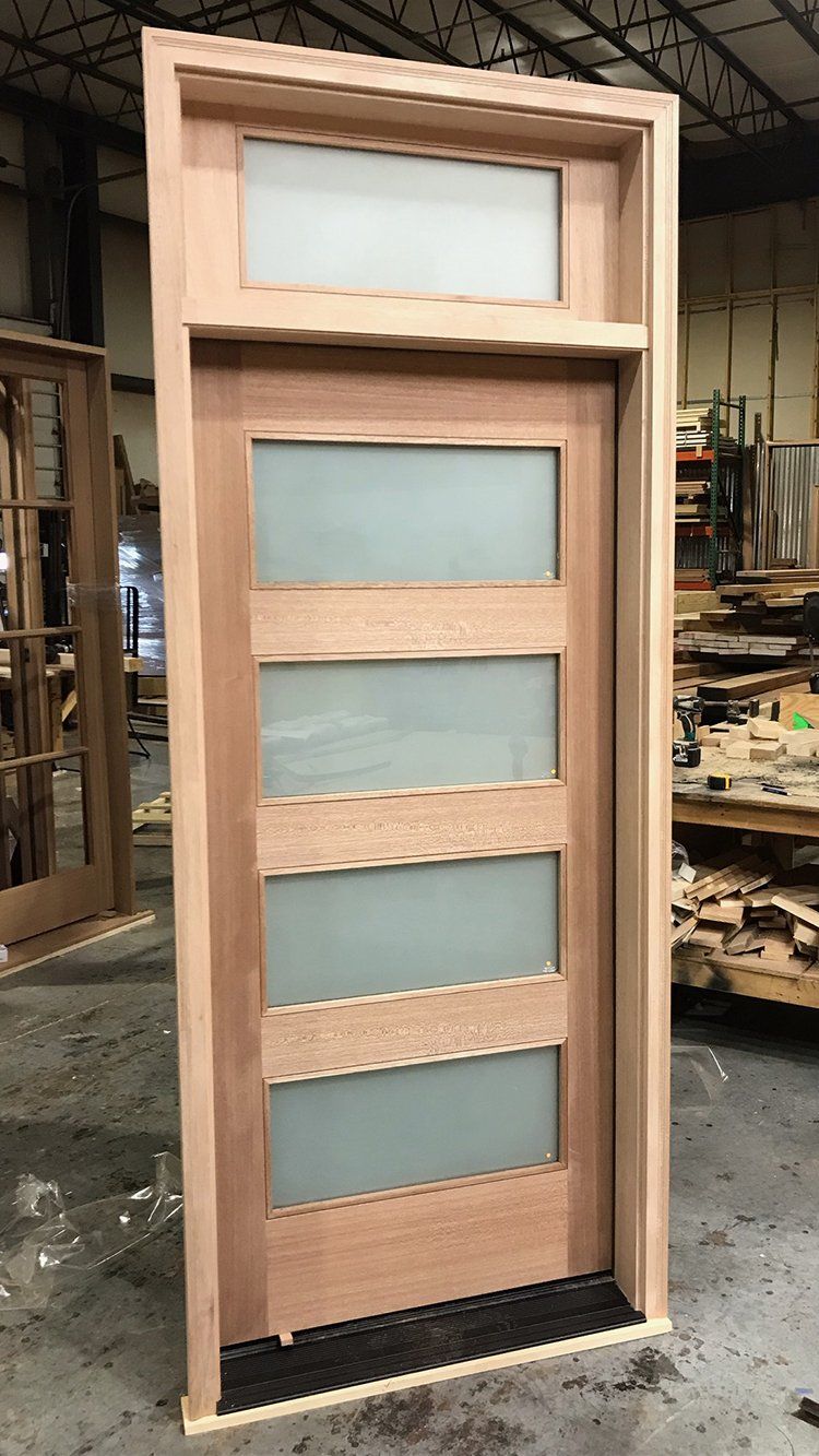 Modern mahogany door features satin glass and custom transom