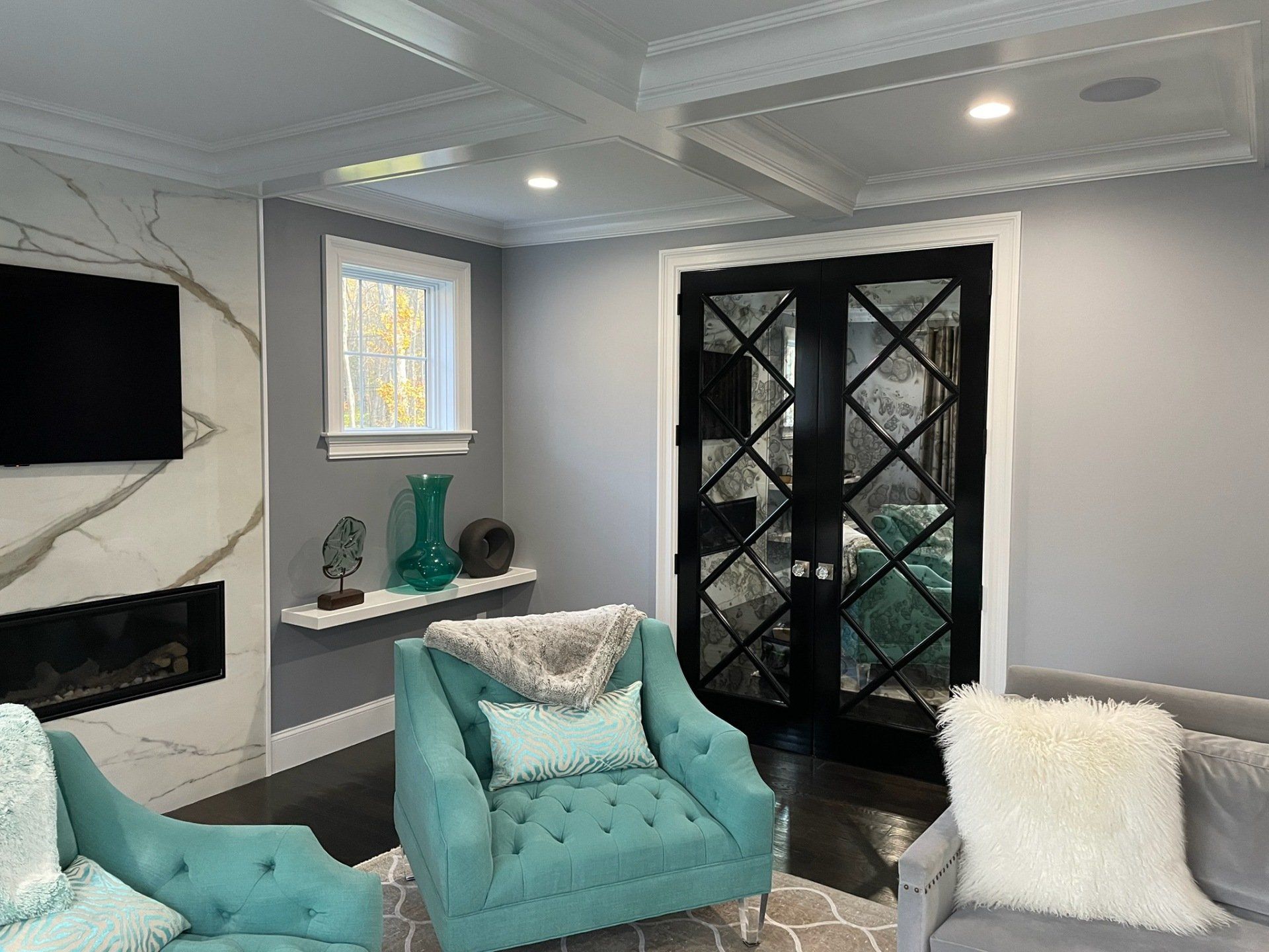 A living room with two chairs , a couch , a fireplace and a television.