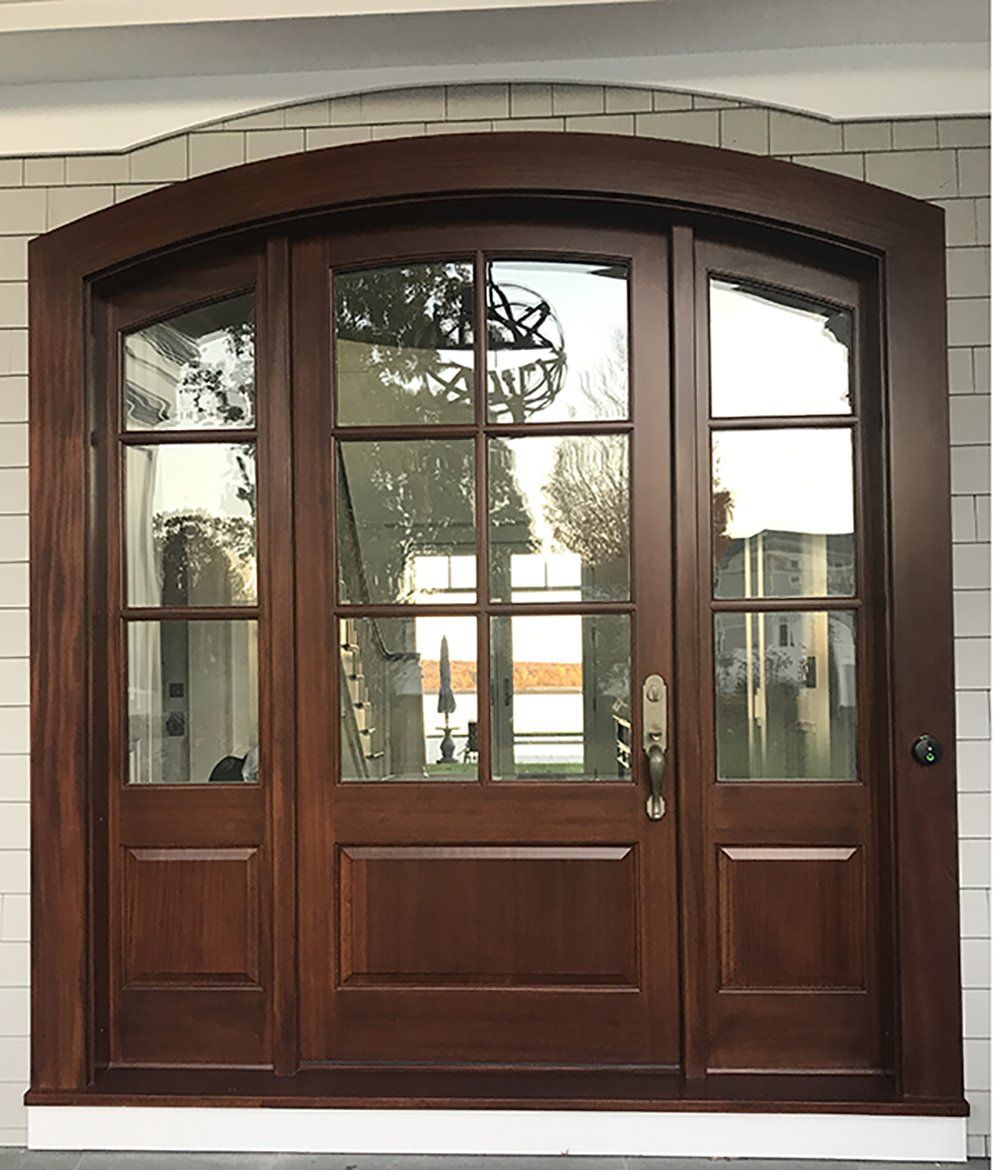 A wooden door with a brick wall behind it