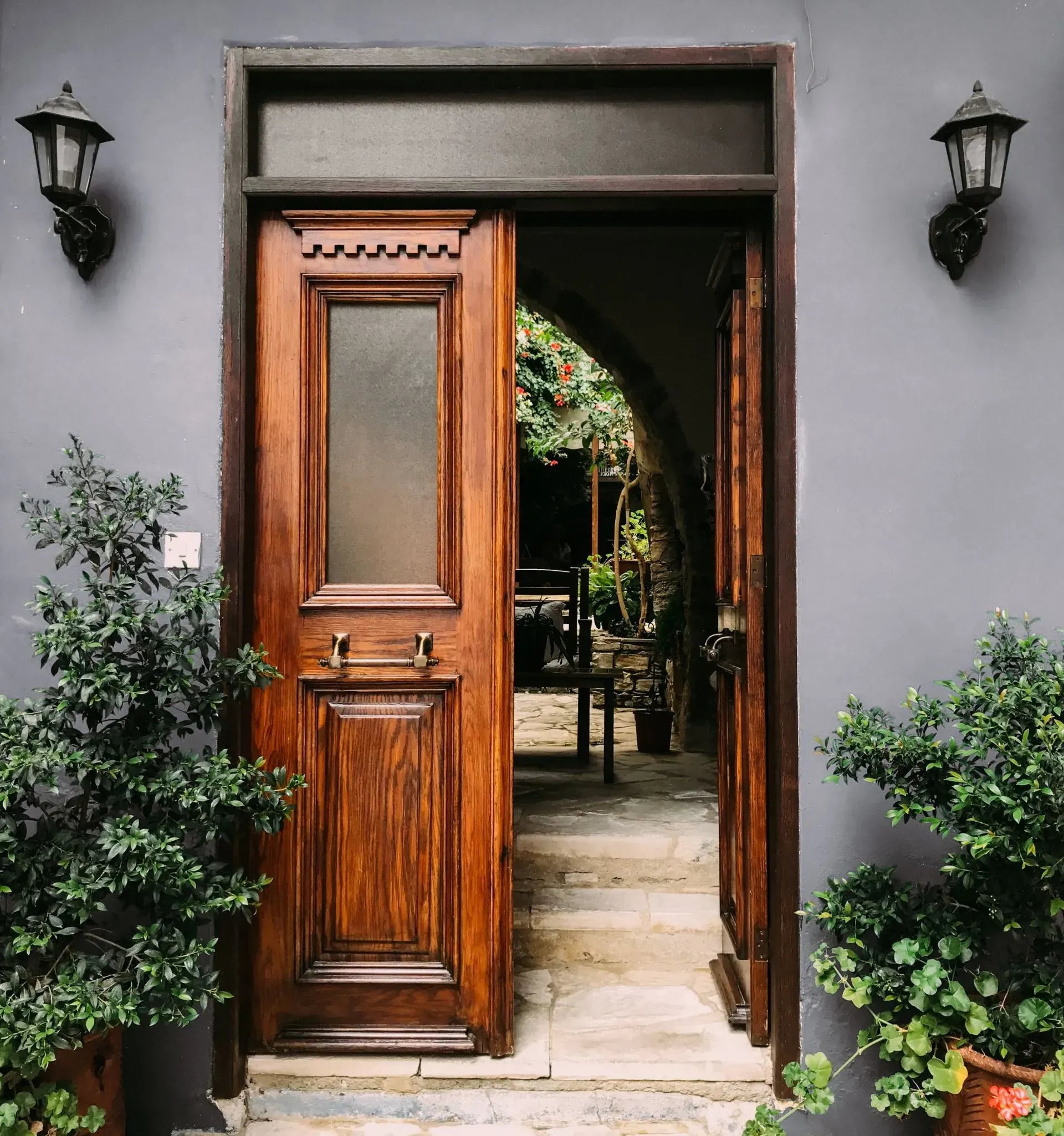 A wooden door is open to a gray wall
