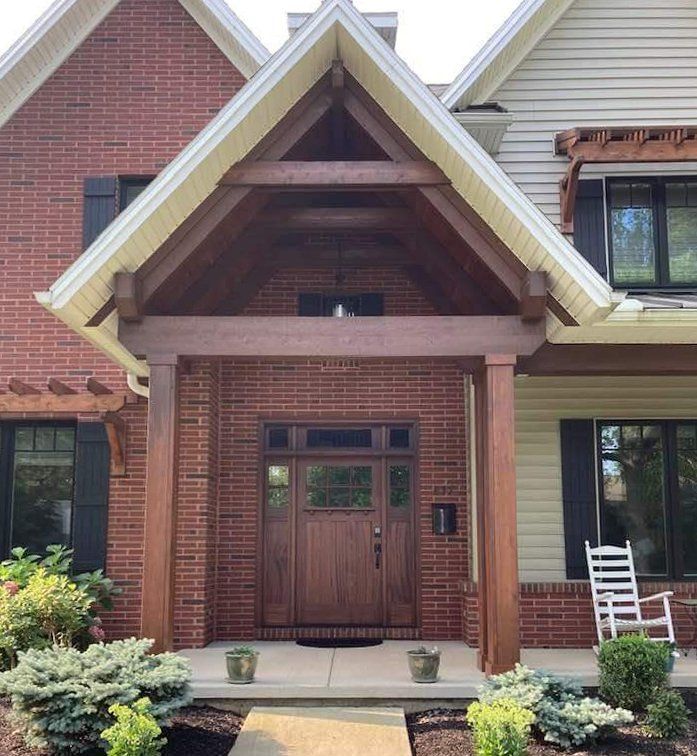 A brick house with a porch and a wooden door