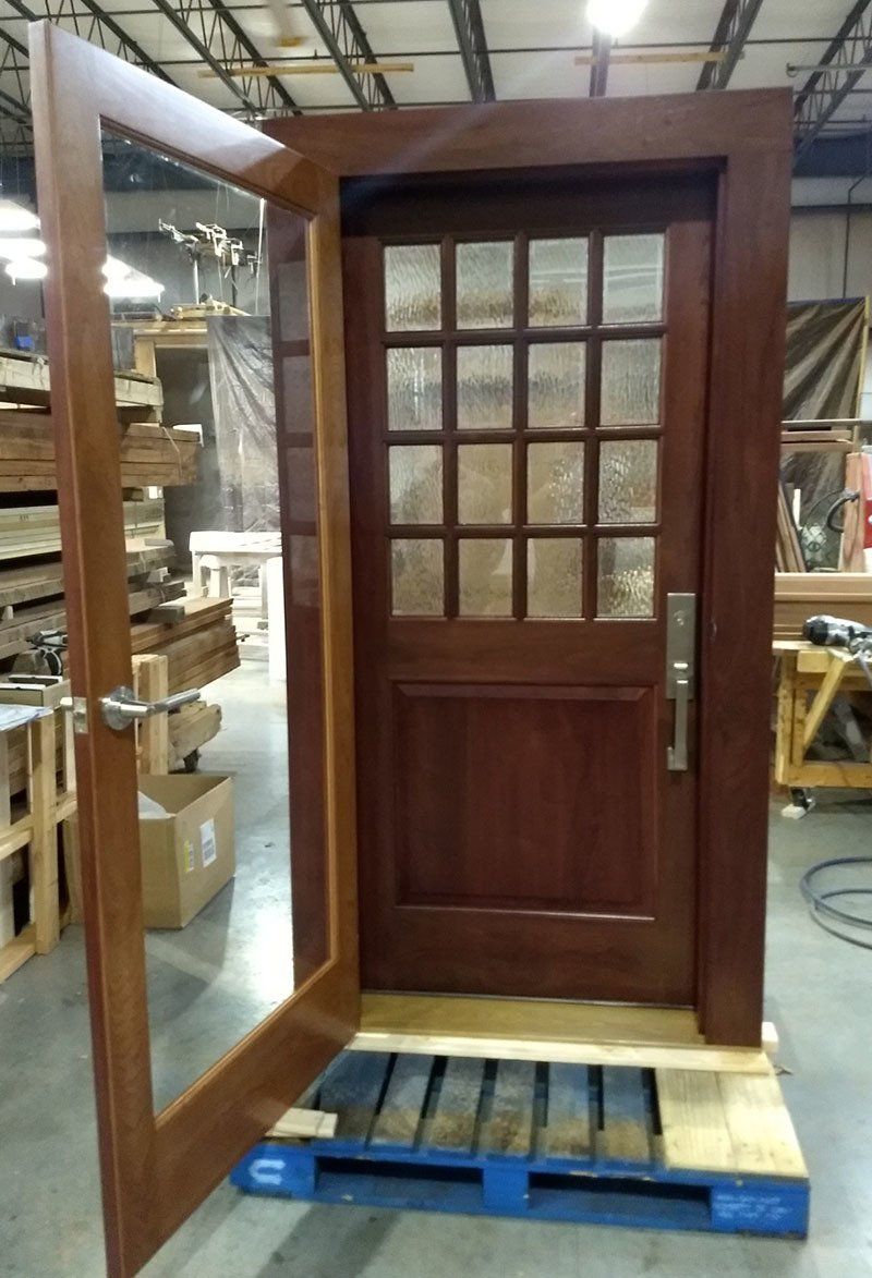 A wooden door is sitting on a blue pallet in a warehouse.