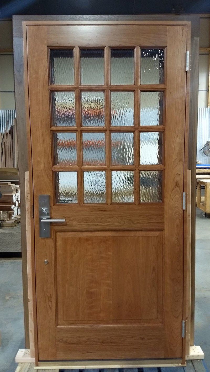 A wooden door with stained glass is sitting on top of a wooden pallet.
