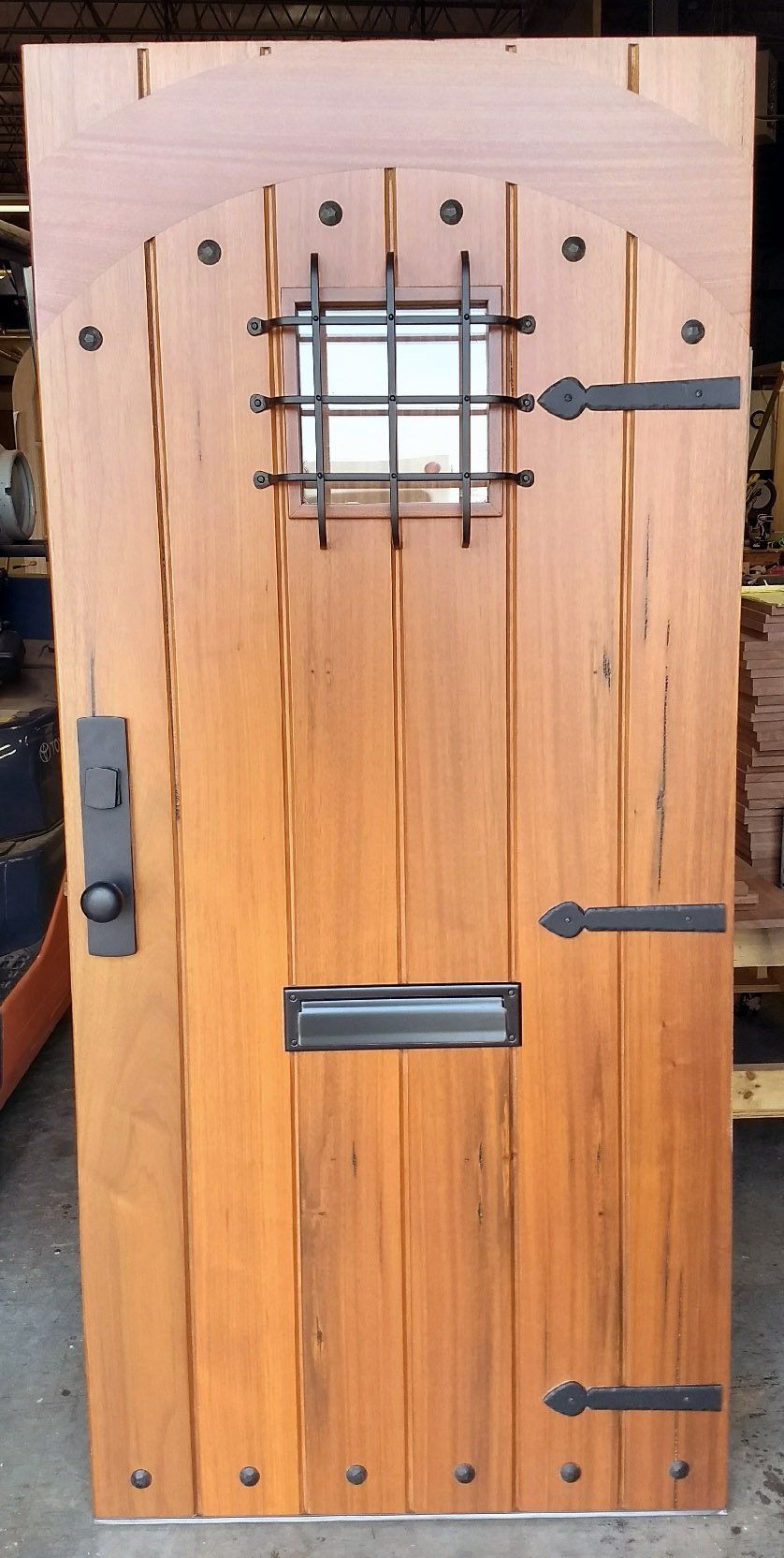 A wooden door with a small window and a black handle.