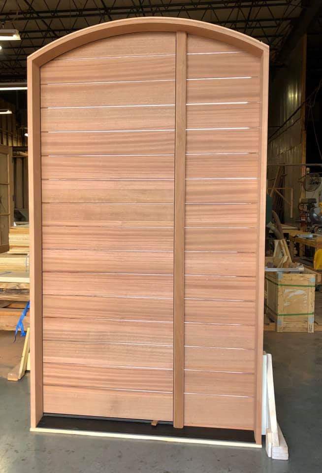 A large wooden door is sitting in a warehouse.