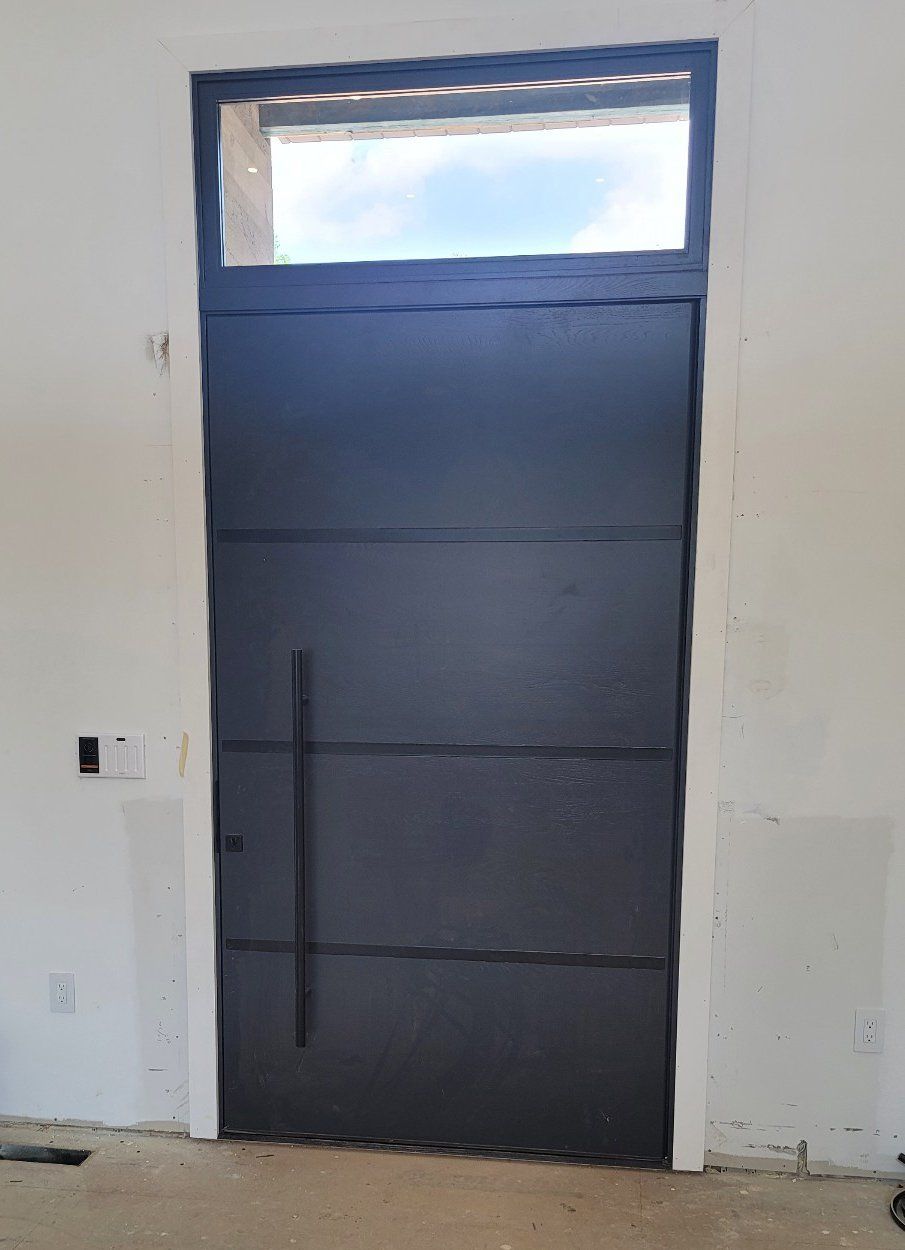 Modern pivot door with metal inlay and transom