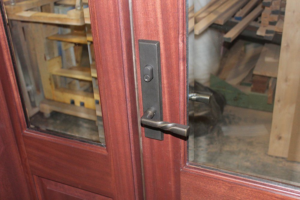 A close up of a wooden door with a metal handle.