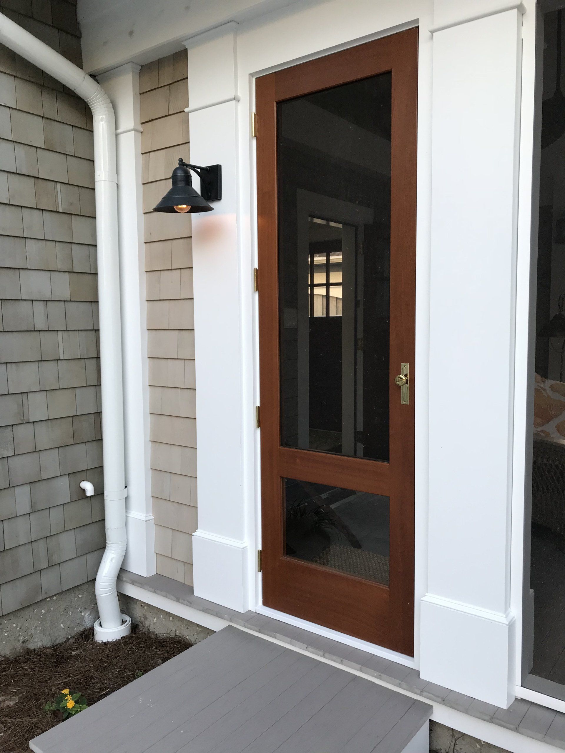 The front door of a house with a screen door