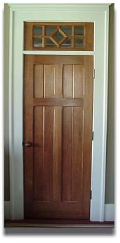 A wooden door with a window above it in a room.