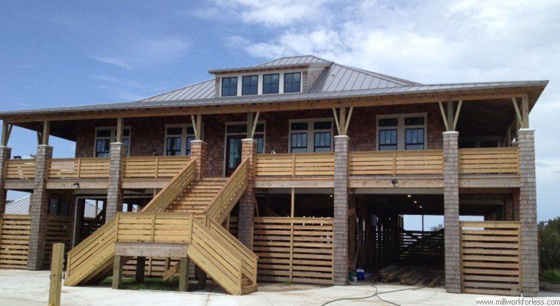 A large brick house with wooden decks and stairs