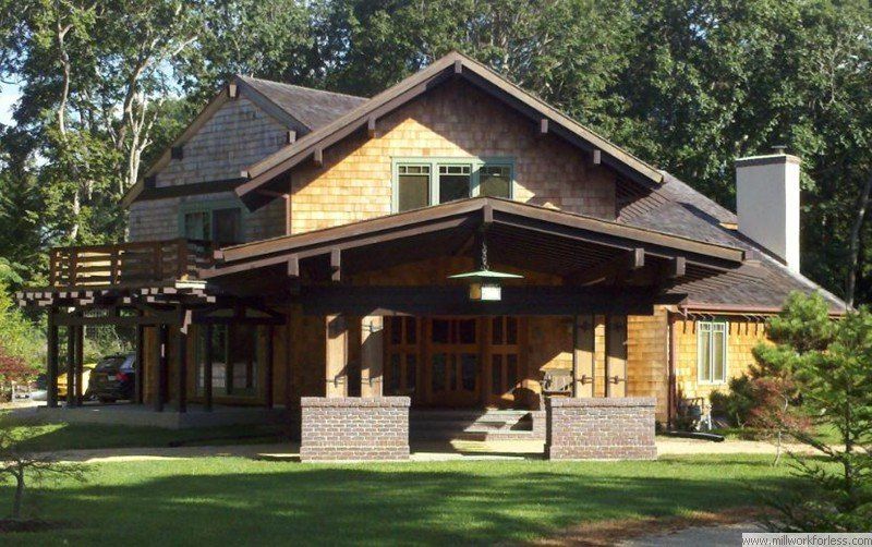 A large house with a porch and a car parked in front of it
